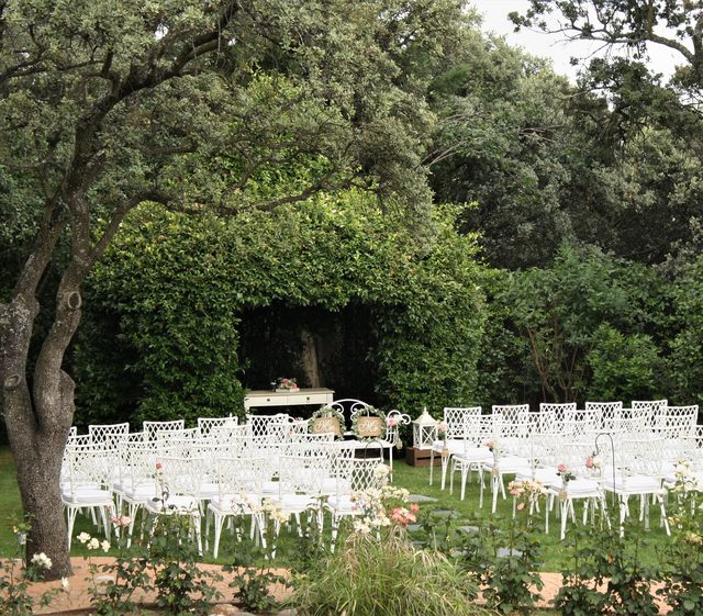 Sillas de ceremonia bajo los árboles del jardín