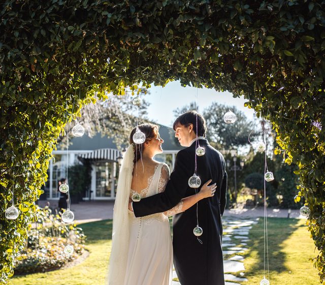 Pareja bajo el arco vegetal del jardín