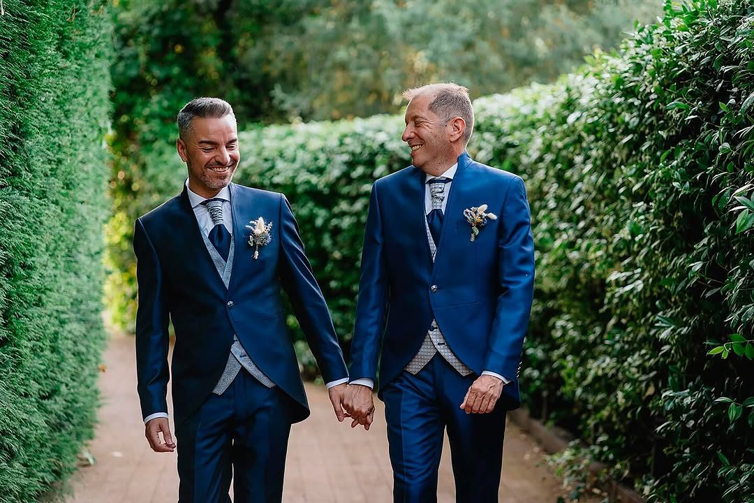 Los novios de la mano, paseando entre los setos