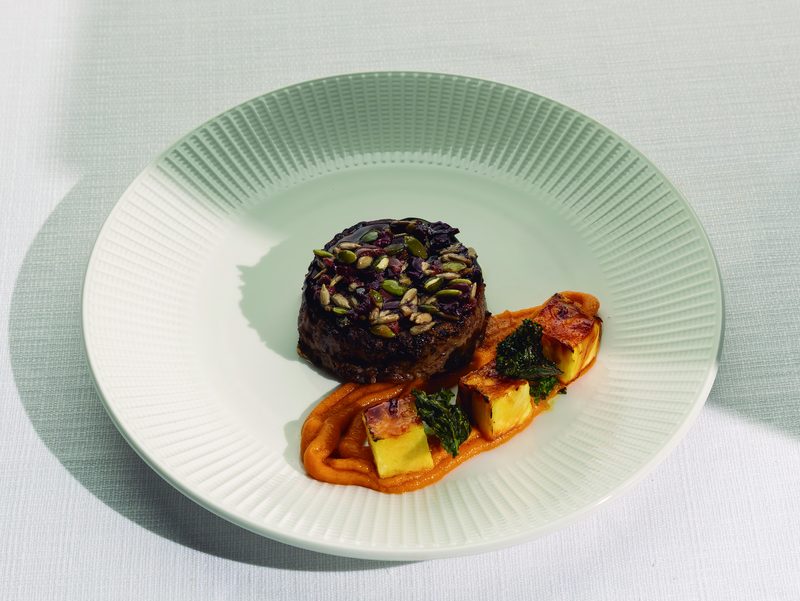 Plato emplatado de Life Gourmet sobre mantel blanco, con luz de día