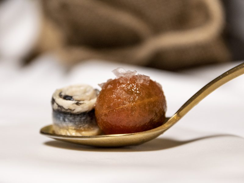 Bocado de cuchara servido en cuchara dorada