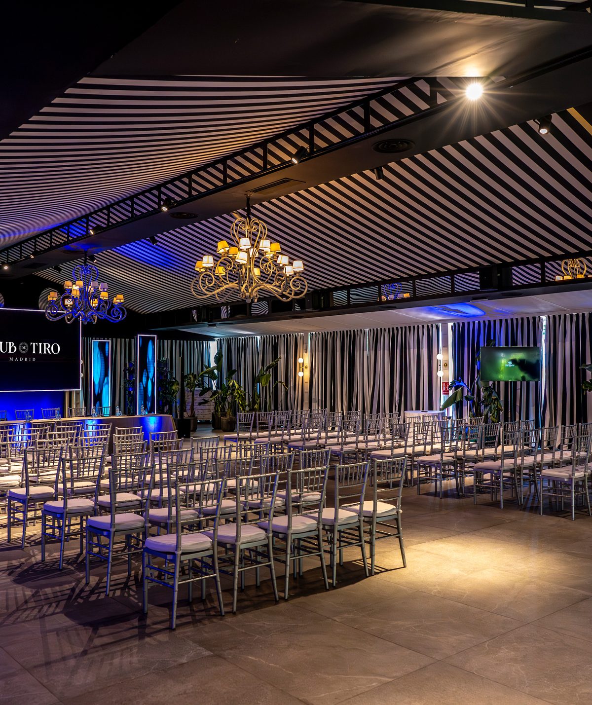 Escenario con branding de la casa y plenaria montada