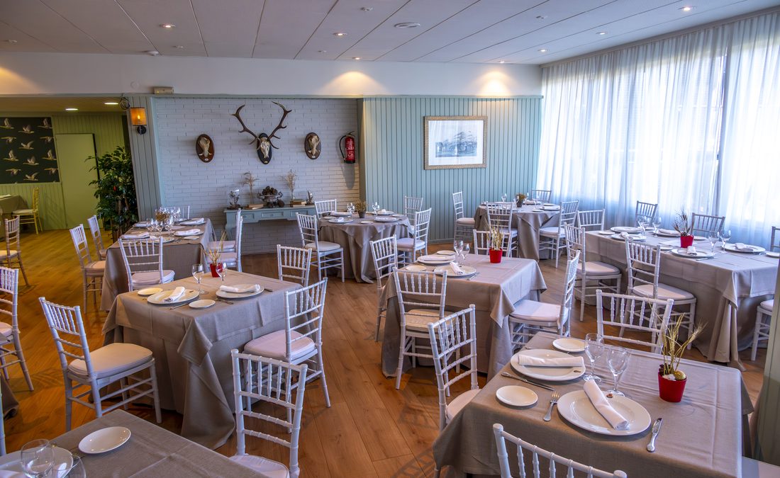 Sala con trofeos de caza y mesas vestidas en gris