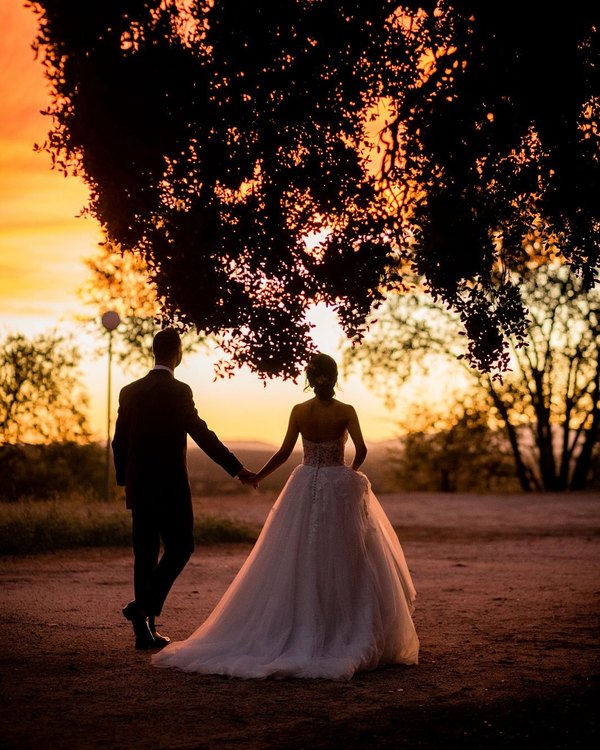 Los novios recortados contra el atardecer